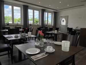 a dining room with tables and chairs and windows at Hotel Leitner in Kaufbeuren