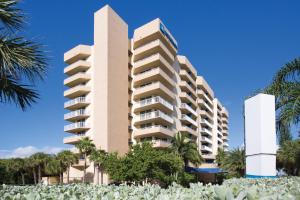 Un edificio alto con palmeras delante. en Club Wyndham Santa Barbara, en Pompano Beach