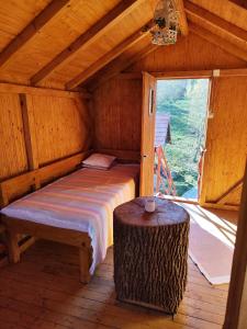 a bed in a wooden room with a window at La sat in Bertea