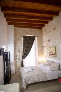 a bedroom with a bed and a large window at Casa Nave in Monopoli