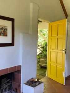 a room with a yellow door and a fireplace at Yellowwoods Farm - POOL COTTAGE (self-catering) in Curryʼs Post