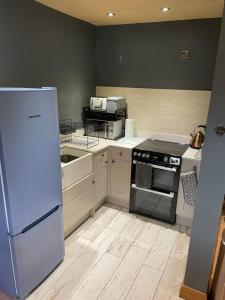 a kitchen with a refrigerator and a stove top oven at Shave Farm in Chard