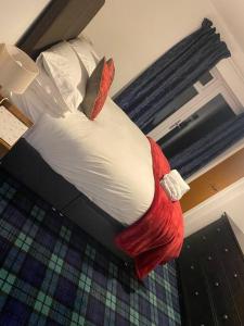 uma cama num quarto com um edredão vermelho e branco em The Cart House 