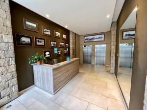 a hotel lobby with a reception counter and pictures on the wall at MINI LOFT Departamentos Bariloche in San Carlos de Bariloche