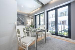 a dining room with a table and chairs and windows at Charming apartment in Kolonaki in Athens