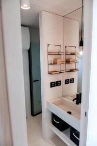 ein Bad mit einem Waschbecken und einem Spiegel in der Unterkunft Buqez resort Drage, villa Vita 50 in Pakoštane