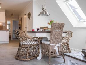 cocina con sillas de mimbre y mesa en una habitación en von Witte 2, en Zingst