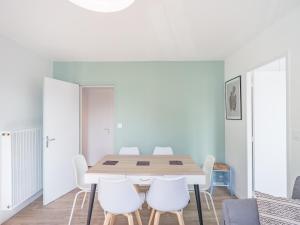 une salle à manger avec une table et des chaises blanches dans l'établissement Le St Lambert Proche Cathédrale Parking gratuit, à Troyes