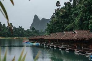 un grupo de edificios en un río con árboles en PraiwanRaftHouse แพไพรวัลย์, en Ban Wang Khon