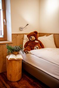 a teddy bear sitting on top of a bed at Appartamento Abete in Livigno