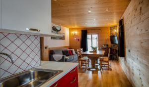 una cucina e un soggiorno con lavandino e tavolo di Appartamento Abete a Livigno