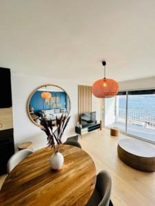 a dining room with a table and a mirror at LES BAUX 2 Sanary sur mer in Sanary-sur-Mer