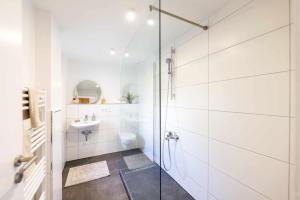 Un baño blanco con ducha y lavabo. en Spacious 6 Room Flat *Balcony & Terrace*, en Darmstadt 24 fotos más