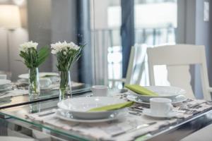 een glazen tafel met witte borden en bloemen erop bij Charming apartment in Kolonaki in Athene