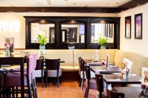 a restaurant with tables and chairs and a bench at Campanile Milton Keynes - Fenny Stratford in Milton Keynes
