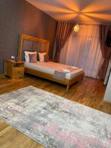 Un dormitorio con una cama y suelo de madera. en ANDRADA WEDDING HALL, en Repedea