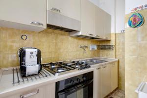 une cuisine avec une cuisinière et un évier dans l'établissement Appartamento Le Vele, à Borghetto Santo Spirito