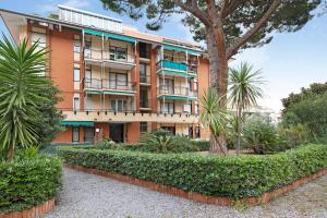 un immeuble d'appartements avec des arbres devant dans l'établissement Appartamento Le Vele, à Borghetto Santo Spirito