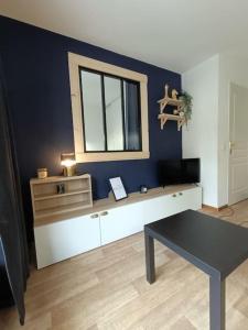 a living room with a table and a mirror at Snowliday - Appartement Rénové en résidence 4* pour 4 pers. Valmeinier 1900 in Valmeinier