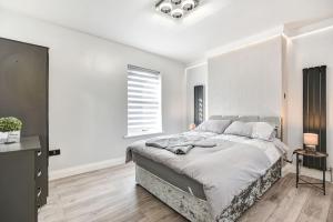 a white bedroom with a large bed and a window at Beauty Close to Coast, Stunning interior, By Air Premier in Newhaven