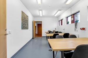 una clase con mesas y sillas en una habitación en Víðines Guesthouse, en Reikiavik