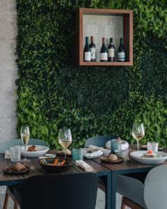 a table with plates of food and wine glasses at Porto Covo Praia Hotel & SPA in Porto Covo