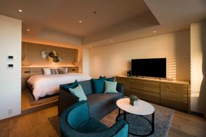 逗子市にあるMALIBU HOTELのベッド、ソファ、テレビが備わるホテルルームです。