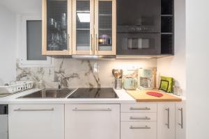 una cocina con armarios blancos y fregadero en Luxurious apartment in Kolonaki, en Atenas