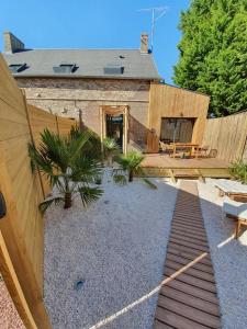 a backyard with a wooden fence and a house at L'escapade Romantique in Dreuil-lès-Amiens