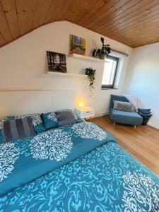a bedroom with a blue bed and a chair at "Stone's throw" KRUMLOV 5 min by car, LIPNO 15 min by car, 2 bdrooms,playroom in Kájov