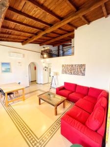 un soggiorno con divano rosso e tavolo di Ulisse's LOFT - Incantevole vista mare, centro storico e spiaggia a piedi - wifi a Terracina