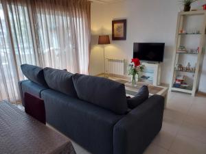 a blue couch in a living room with a tv at Casa Bacaladilla - A Murcia Holiday Rentals Property in Roldán