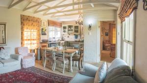 a living room with a table and a kitchen at The French Cottage in Clarens