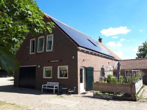 a brick house with a bench in front of it at “In Oans Oefje” Parel in de polder! in Lewedorp