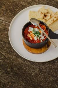 a white plate with a bowl of chili and tortilla chips at Kai 36 - Hotel zwischen Fels und Fluss in Graz