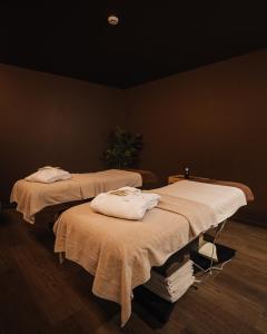 two beds in a dark room with towels on them at Porto Covo Praia Hotel & SPA in Porto Covo