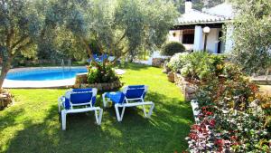 einen Garten mit zwei Stühlen und einem Pool in der Unterkunft El Chorro Villas Casa Rosaleda in El Chorro