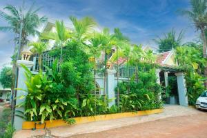 a house with palm trees in front of it at Mohasal Angkor Boutique in Siem Reap