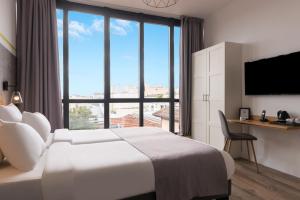 a hotel room with a bed and a large window at Hotel Terre Neuve in Paris