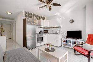 eine Küche und ein Wohnzimmer mit einem Deckenventilator in der Unterkunft Los Geranios 304 in Adeje