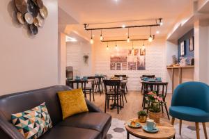 a living room with a couch and tables and chairs at Hotel Terre Neuve in Paris