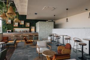 a bar with chairs and tables in a room at Porto Covo Praia Hotel & SPA in Porto Covo