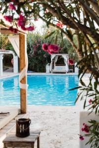 Blick auf einen Pool mit einem Tisch und ein paar Blumen in der Unterkunft Can Vistabella Boutique Resort in Sant Antoni de Portmany