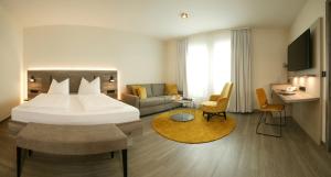 a hotel room with a bed and a living room at Hotel & Restaurant Sonne in Rudersberg