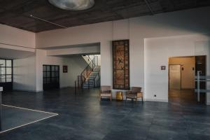 an empty room with two chairs and a staircase at Porto Covo Praia Hotel & SPA in Porto Covo