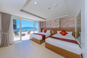 two beds in a room with a view of the ocean at Dubai Nha Trang Hotel managed by HT in Nha Trang +60 photos