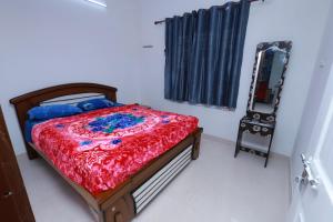 a bedroom with a bed and a mirror and a chair at 7coloursholidays in Kanthalloor