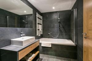 La salle de bains est pourvue d'un lavabo et d'une baignoire. dans l'établissement All-Suite Resort Kühtai, à Kühtai