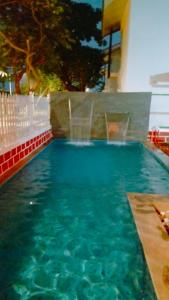 a swimming pool with a water fountain in a building at 4 Bedroom Premium Pool Villa in SOUTH GOA in Dabolim