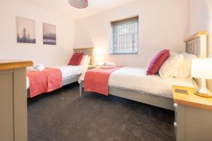 2 camas en una habitación con sábanas rojas y blancas en Modern City Centre Apartment in Inverness, en Inverness